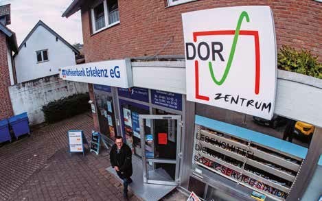 Frontansicht von drau&szlig;en auf den Dorfladen. Zu sehen sind Schilder von der Raiffeisenbank Erkelenz und dem Dorf-Zentrum